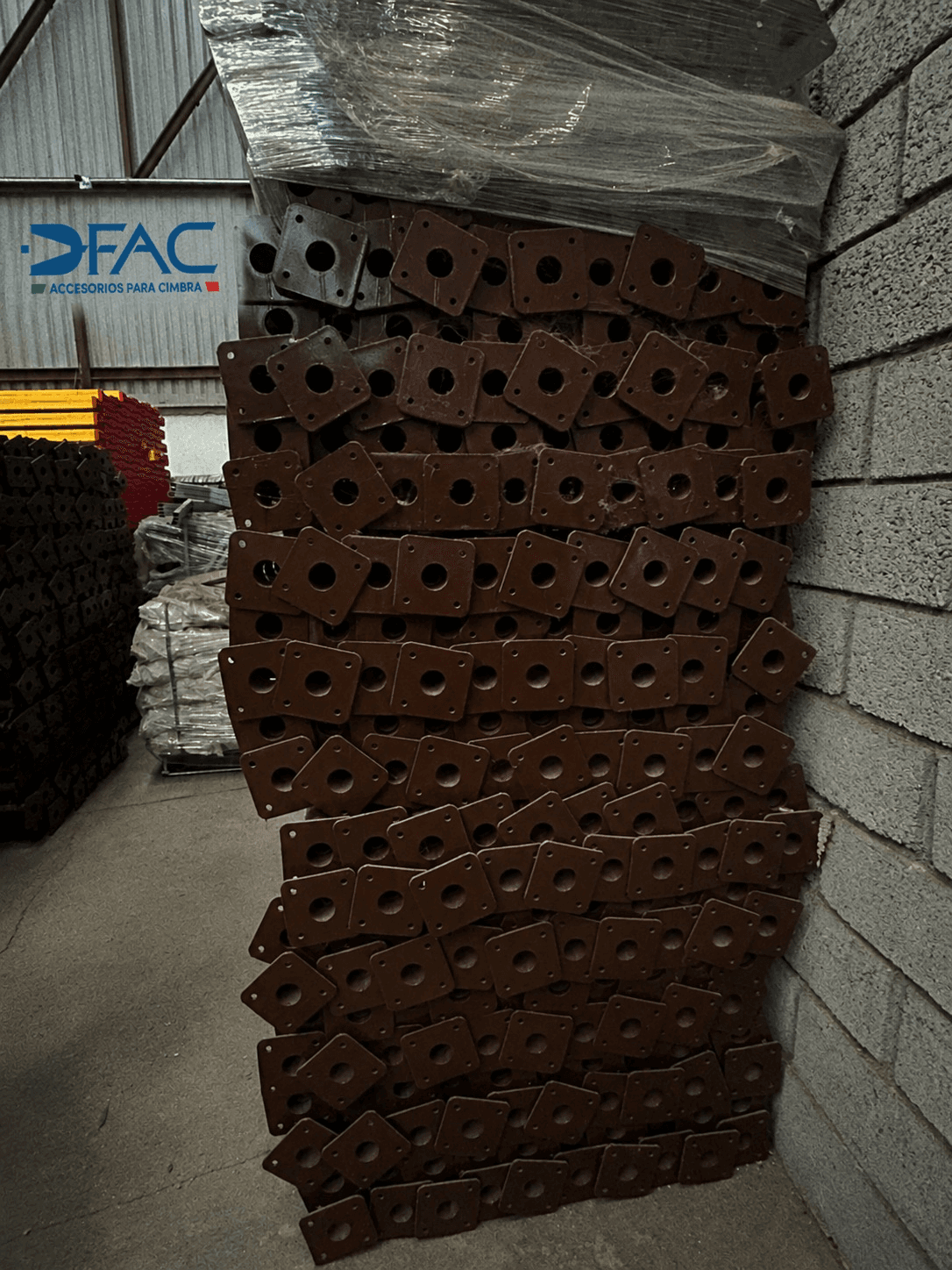 Bases de acero para puntales metálicos extensibles apiladas en bodega DFAC